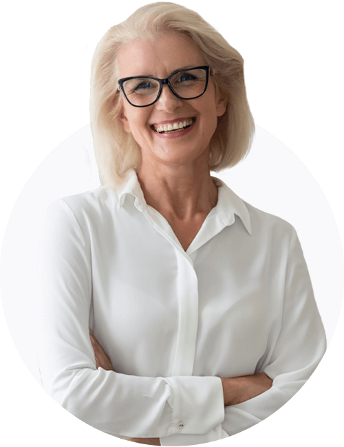 A professional older woman in white shirt smiling at the camera with her arms crossed.